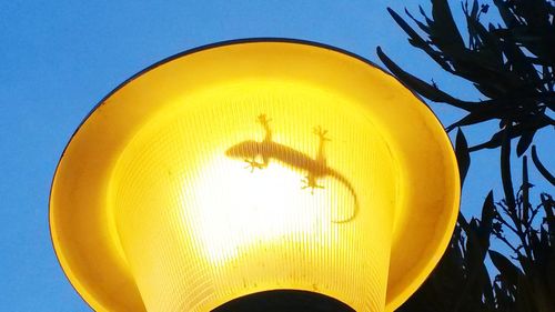 Close-up of yellow light against blue sky