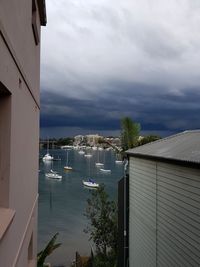 Scenic view of sea by buildings against sky