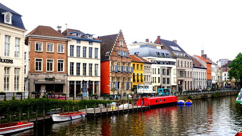 Canal amidst buildings against sky in city