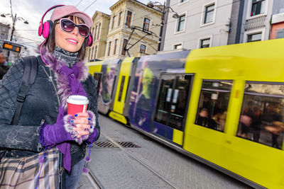 Smiling woman by cable car on street