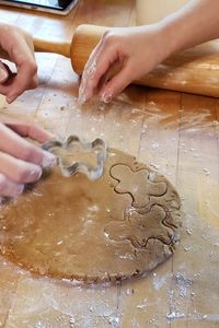 Cropped hands using pastry cutters on dough