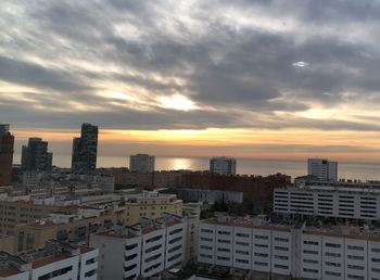 Buildings in city against sky during sunset