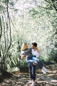 Rear view of couple kissing against trees