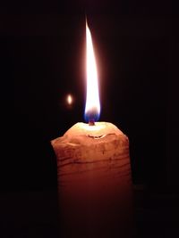 Close-up of illuminated candle in darkroom