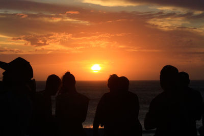 Silhouette people on beach during sunset