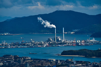 High angle view of townscape by sea against sky