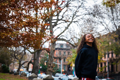 Happy girl standing at park in city