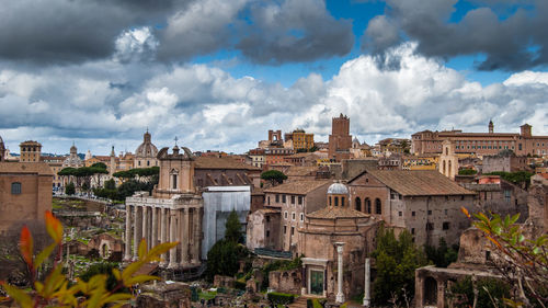 Panoramic view of buildings against cloudy sky