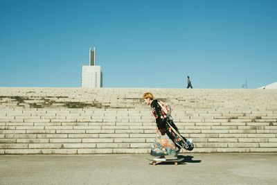 Rear view of woman standing on railing