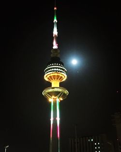 Low angle view of illuminated buildings against sky at night