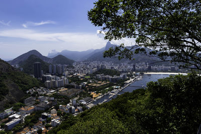 Aerial view of city by mountains against sky