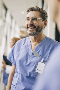 Happy mature male doctor in scrubs at hospital