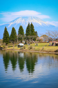 Scenic view of lake by trees against sky