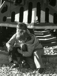 Rear view of boy sitting outdoors