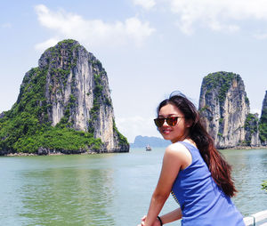 Rear view portrait of woman standing on boat at halong bay