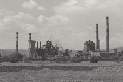 Factory against cloudy sky