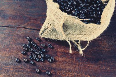 High angle view of roasted coffee beans in sack on table