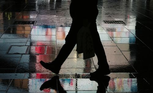 Low section of person walking on wet window