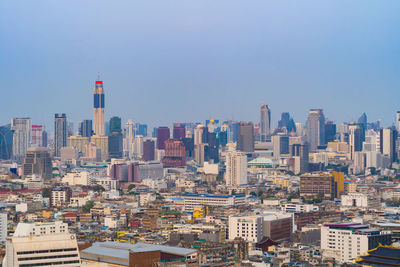 Aerial view of buildings in city against clear sky