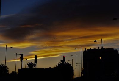 Low angle view of silhouette buildings against sky during sunset