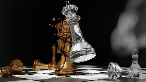 Close-up of chess pieces on table against black background