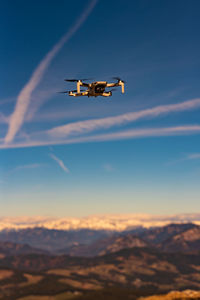 Low angle view of drone flying in sky