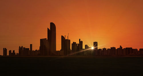 Silhouette of buildings in city during sunset