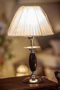 Close-up of illuminated lamp on table at home