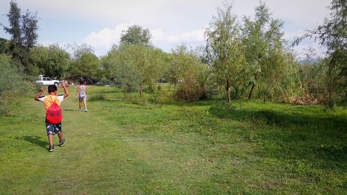 Rear view of man on field against sky