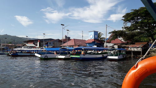 Sailboats moored at harbor