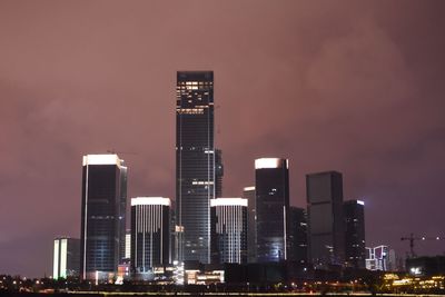 Low angle view of illuminated skyscrapers against sky at night