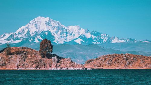 Scenic view of sea and mountains against sky