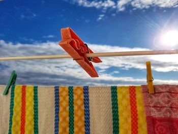 Low angle view of clothespins on clothesline against sky