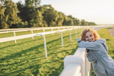 Rear view of woman standing on railing