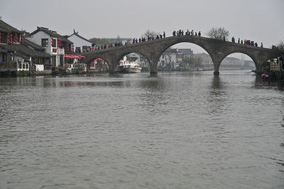 Arch bridge over river against sky