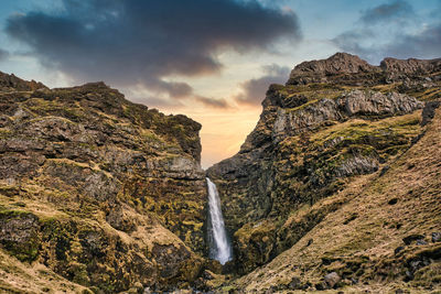 Scenic view of waterfall against sky