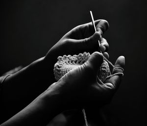 Close-up of hand holding finger against black background