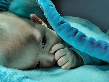 Close-up portrait of cute baby lying on bed