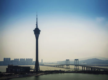 View of communications tower and buildings against sky