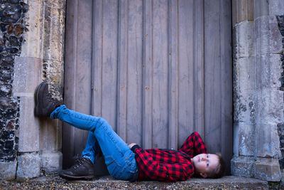 Boy lying on floor against wall