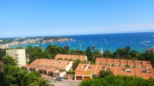 Scenic view of city by sea against clear sky