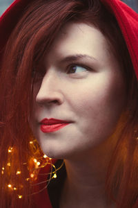 Close up happy woman with red lipstick and fairy lights portrait picture