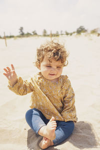 Cute baby girl sitting on beach