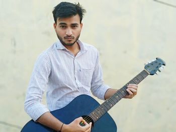 Portrait of young man playing guitar