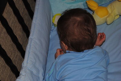 Baby boy playing in crib at home