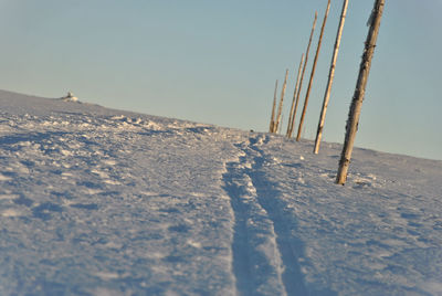 Snow covered landscape against sky