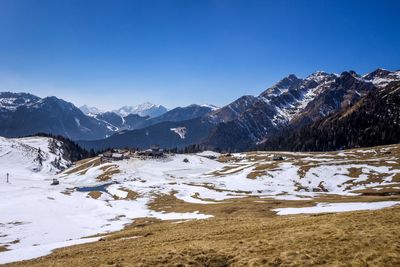 Scenic view of snowcapped mountains against clear blue sky