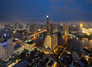 Illuminated cityscape against sky at night