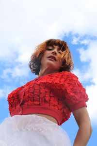 Low angle view of young woman against sky