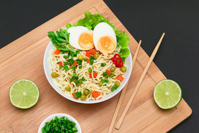 Noodle dish with green pea, carrot, eggs, red hot pepper and greens